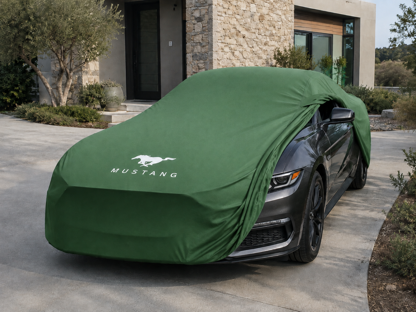 Ford Mustang with a green custom-fit indoor cover partially removed to show the tailored fit